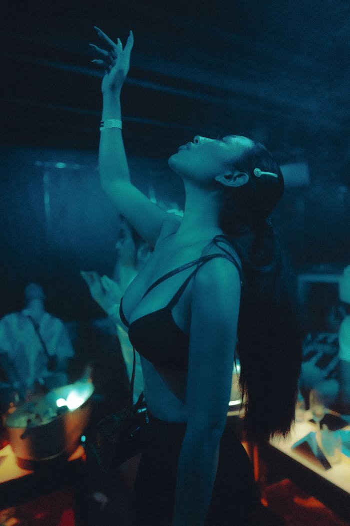 gallery-02 Young woman dancing energetically in a vibrant nightclub setting, capturing joyful nightlife vibes.